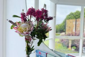 un jarrón de flores sobre una encimera en una ventana en Southern Heights, en Lavers Hill