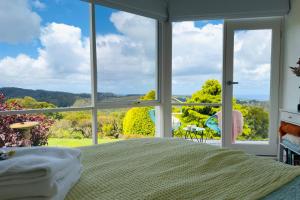 Un dormitorio con una cama y una ventana grande en Southern Heights, en Lavers Hill