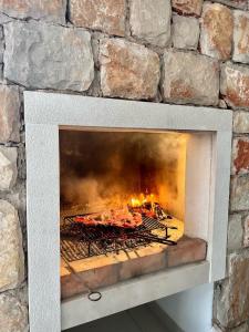 una chimenea de piedra con fuego en Isolated apartments with a swimming pool Cove Tvrdni Dolac, Hvar - 6112, en Gdinj