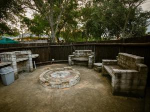 a group of benches and a fire pit in a backyard at Weavers Nest Guesthouse in Modimolle +2 photos