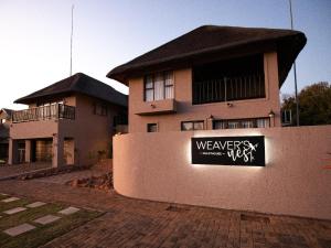 a building with a sign on the side of it at Weavers Nest Guesthouse in Modimolle