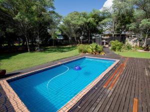 a swimming pool with blue water in a yard at Weavers Nest Guesthouse in Modimolle