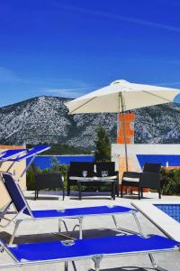 - une piscine avec une table, un parasol et des chaises dans l'établissement Seaside apartments with a swimming pool Kneza, Korcula - 9269, à Račišće