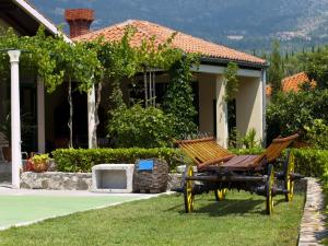 een bank in het gras voor een huis bij Luxury villa with a swimming pool Zastolje, Dubrovnik - 14922 in Gruda