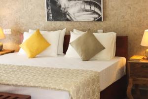 ein Hotelzimmer mit einem Bett mit gelben Kissen in der Unterkunft Villa 1818 - Wellawaya in Wellawaya