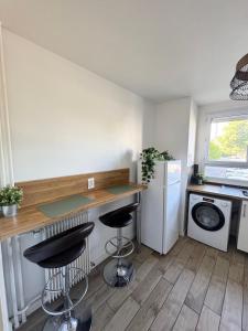 a kitchen with a counter and two bar stools at Chambre Monde Tout confort Saint-Marceau in Orléans +5 photos