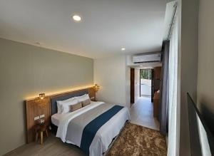 a bedroom with a large bed and a hallway at la la lay beach house in Tab Kaek Beach