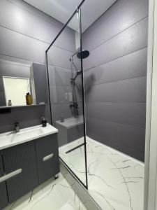 a bathroom with a glass shower and a sink at Отель Жанатас in Zhangatas