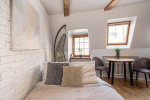 a bedroom with a bed and a table and chairs at Old Town Gem - Rooftop Studio - By Innorental in Rīga
