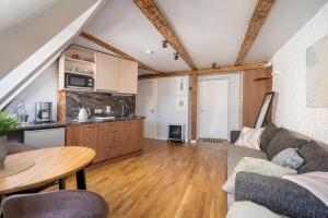 a living room with a couch and a table at Old Town Gem - Rooftop Studio - By Innorental in Rīga +9 photos