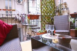 a table with two wine glasses on a balcony at Sunrise B&B in Naples