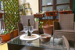 a glass table with two glasses and a bottle of wine at Sunrise B&B in Naples
