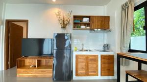 a kitchen with a stainless steel refrigerator and a sink at Ali Cozy Houses in Ban Thalat Choeng Thale