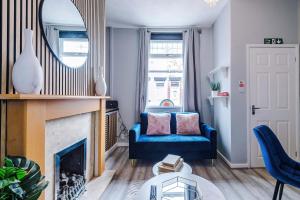 un salon avec un canapé bleu et un miroir dans l'établissement St Helens Central, 2 Bed , Long Stay OFFERS, Contractors, Relocations, Families, Sleeps 4, à St Helens