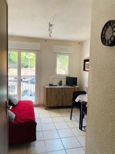 a room with a bed and a desk with a television at Le petit soleil in Lamalou-les-Bains