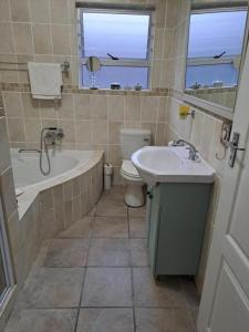 een badkamer met een bad, een toilet en een wastafel bij Milky Way in Hermanus