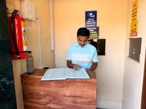 a man is looking at a paper on a table at Hans Dormitory in Mumbai