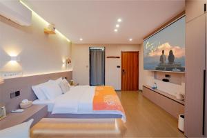 a bedroom with a large bed and a large screen at Yu Ni Meisu-wang xian gu Branch in Qiaotou