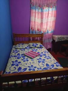 - un lit avec une couette bleue et blanche dans l'établissement River side resort, à Balangoda