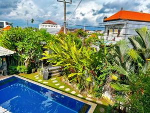 une cour arrière avec une piscine et des plantes dans l'établissement GreatiStay Living&Working Canggu, à Tumbak Bayuh 22 autres photos