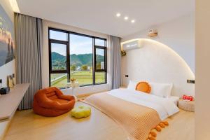 a bedroom with a large bed and a large window at Yu Ni Meisu-wang xian gu Branch in Qiaotou