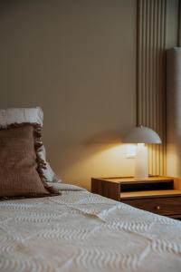 a bedroom with a bed with a lamp and a nightstand at Hotel Vest Mar in Ólafsvík