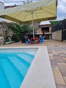 - une piscine avec un parasol, 2 chaises et une table dans l'établissement Family friendly house with a swimming pool Selce, Crikvenica - 18895, à Selce