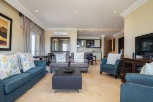 sala de estar con sofás azules y TV en Ballito Manor View 406 - With Generator, en Ballito