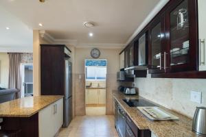 Una cocina con gabinetes de madera y encimera. en Ballito Manor View 406 - With Generator, en Ballito