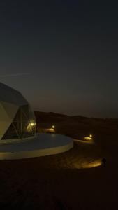a tent in the middle of the desert at night at The mirage dome in Bidiyah