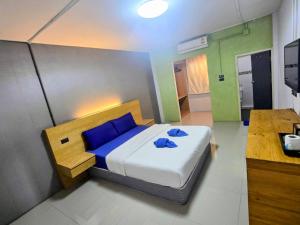 a bedroom with a bed with blue pillows on it at Jonah Hotel in Chiang Mai