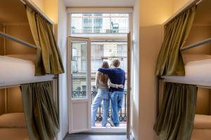 un hombre y una mujer parados frente a una puerta en Camila Hostel Valencia, en Valencia