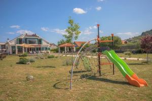 a playground with a slide in a yard at Luxury villa with a swimming pool Vrpolje, Sibenik - 21843 in Šibenik