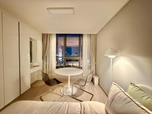 ein Zimmer mit einem Bett und einem Tisch und einem Fenster in der Unterkunft Shine Stay 5 Min from Songdo Moonlit Festiv Park Station in Taeam