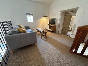 Una sala de estar con un sofá y un televisor. en Maison pure style provençale-jardin clôturé-4 pers, en Collorgues