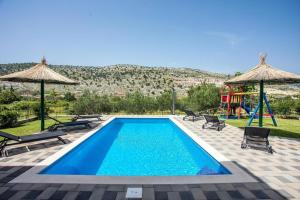 a swimming pool with a slide and a playground at Family friendly house with a swimming pool Srinjine, Split - 23950 in Srinjine