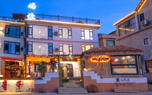 a building with a restaurant in front of it at Yu Ni Meisu-wang xian gu Branch in Qiaotou