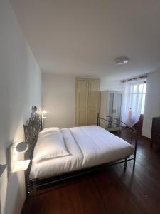 een slaapkamer met een groot bed met witte lakens bij Ca' Santa Maria in Santa Maria Maggiore