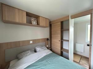Dormitorio pequeño con cama y armarios de madera en Po - Design et confort - 3 ch, 2 sdb, proche plages, gares et aéroport, en Lattes