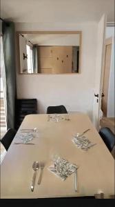 Una mesa con utensilios encima y un espejo. en Po - Design et confort - 3 ch, 2 sdb, proche plages, gares et aéroport, en Lattes