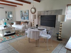 een woonkamer met een tafel en een bank bij Milky Way in Hermanus