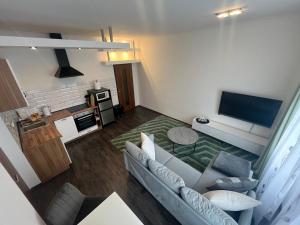 a living room with a couch and a tv at Apartmány PARK in Klášterec nad Ohří +10 photos