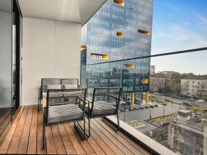un balcone con due sedie e un edificio di vetro di Skyline views a Bucarest