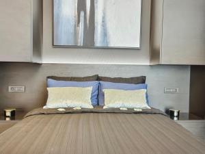 una camera da letto con un letto con cuscini blu e bianchi di Skyline views a Bucarest