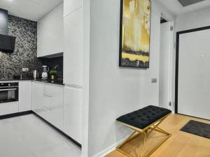 una cucina bianca con uno sgabello nero in una stanza di Skyline views a Bucarest