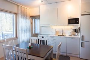 eine Küche mit einem Esstisch und eine Küche mit weißen Schränken in der Unterkunft Levin Stara C 14 Visit Levi in Levi