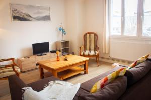 ein Wohnzimmer mit einer Couch und einem Couchtisch in der Unterkunft L Albéra - Elégance et douceur in Albertville