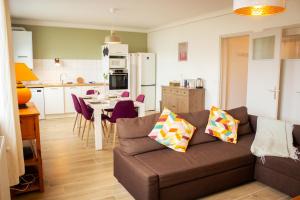 ein Wohnzimmer und eine Küche mit einer Couch und einem Tisch in der Unterkunft L Albéra - Elégance et douceur in Albertville