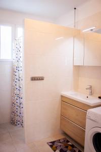 ein Badezimmer mit einer Dusche, einem Waschbecken und einer Waschmaschine in der Unterkunft L Albéra - Elégance et douceur in Albertville