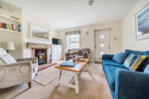 a living room with a blue couch and a table at Avocet Cottage in Brancaster
